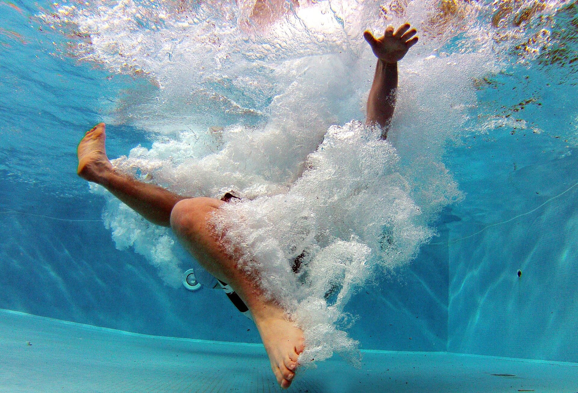 underwater view of boy falling into pool