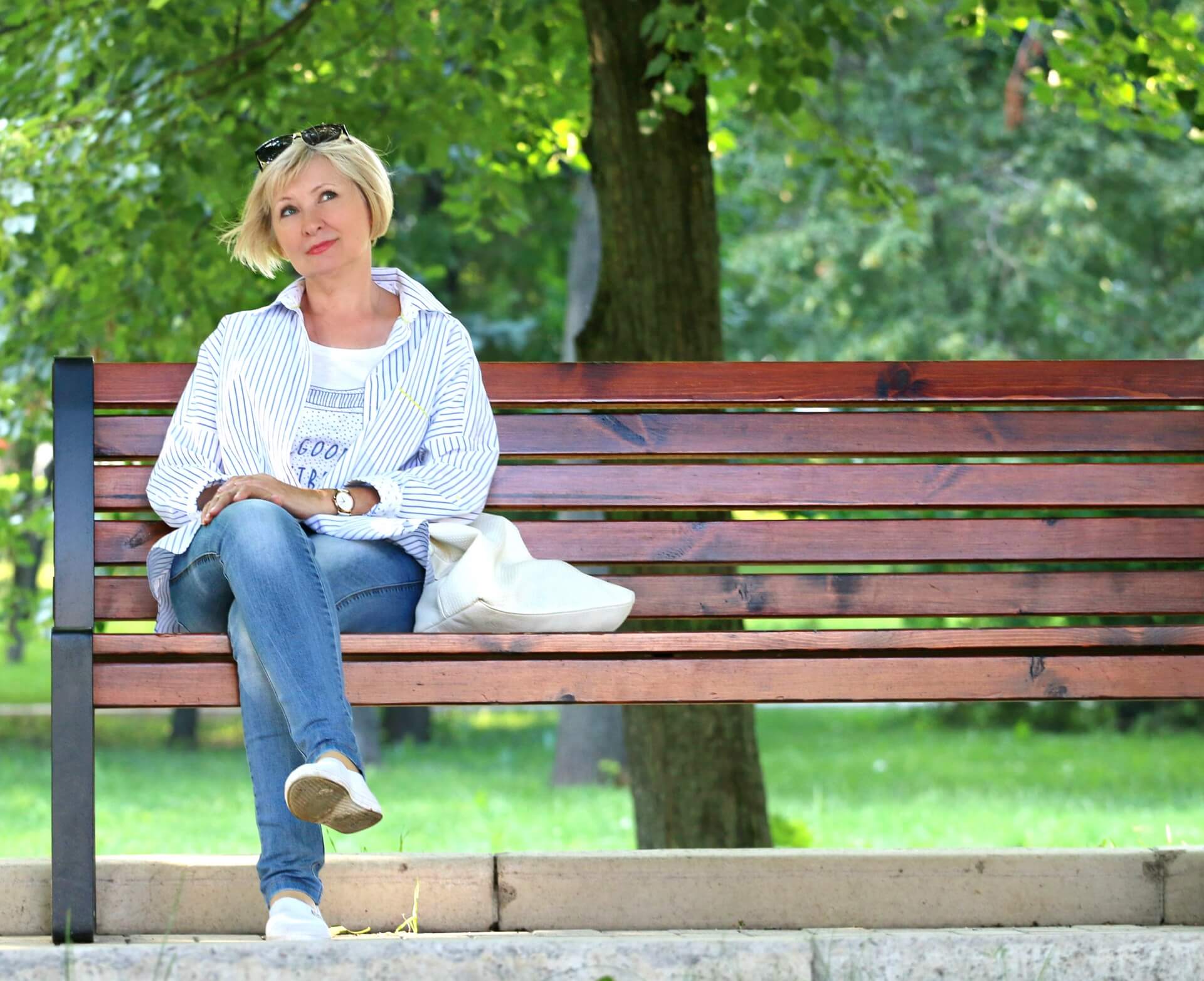 woman sitting on a brown bench outside