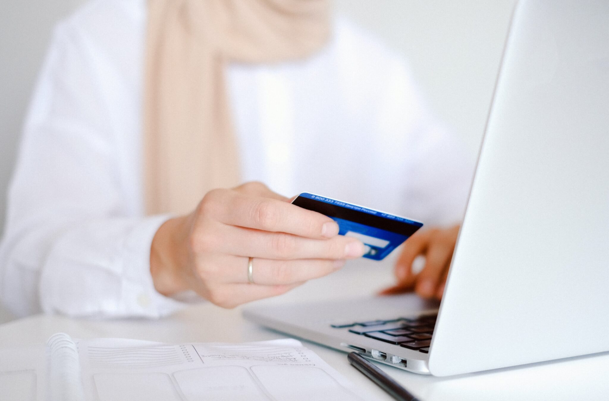 woman holding credit card at laptop